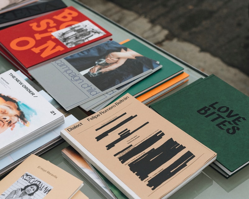 a table topped with lots of books on top of a glass table