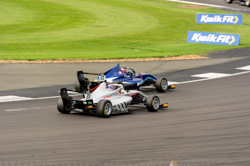 two racing cars racing on a race track