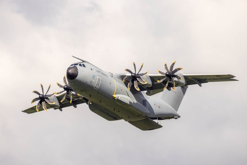 A large air plane flying through a cloudy sky