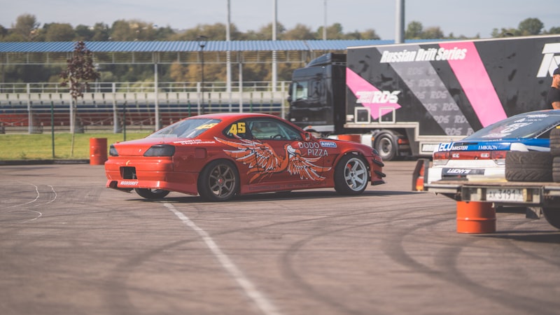 A red sports car driving down a race track