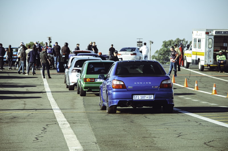 Cars are lined up at a drag racing event.