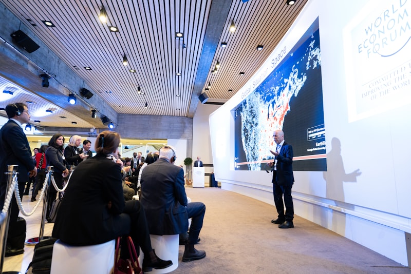 man standing beside projecting wall in front of people