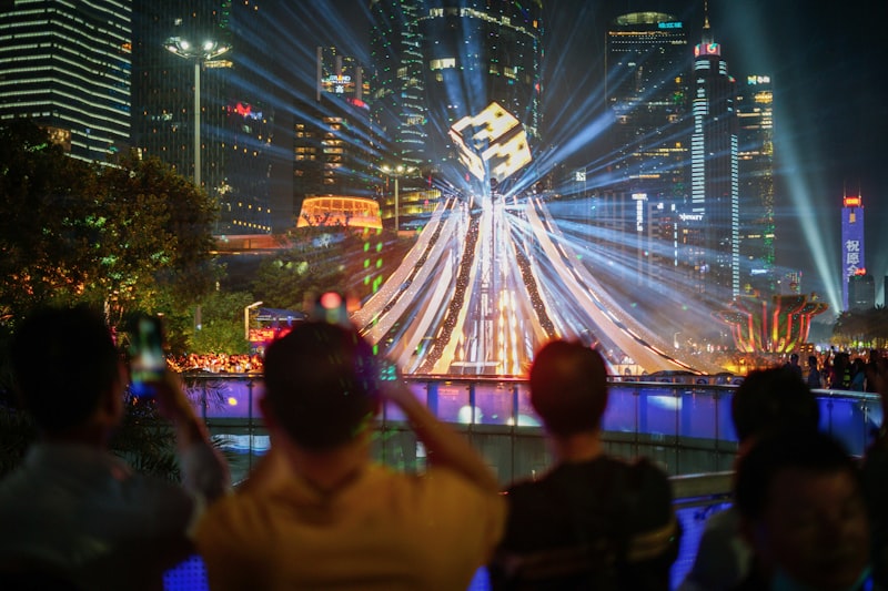 City skyline with light show and spectators at night