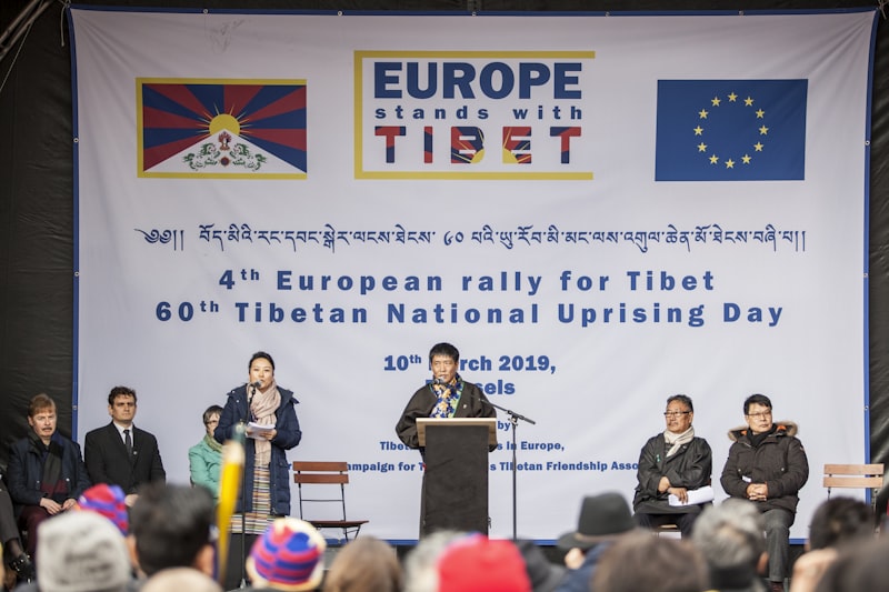 person wearing black jacket standing in front of black wooden lectern