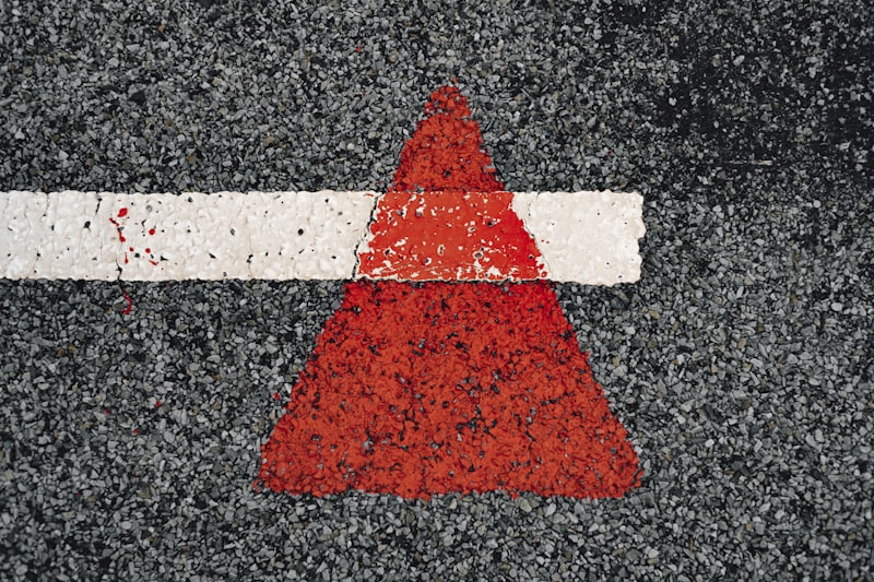 a red and white arrow painted on a road