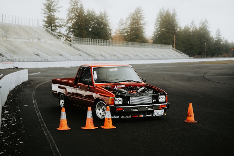 Red truck with its hood open and cones.