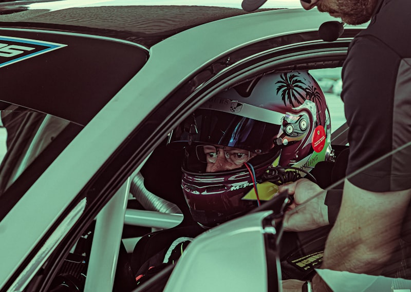 A man sitting in a car with a helmet on