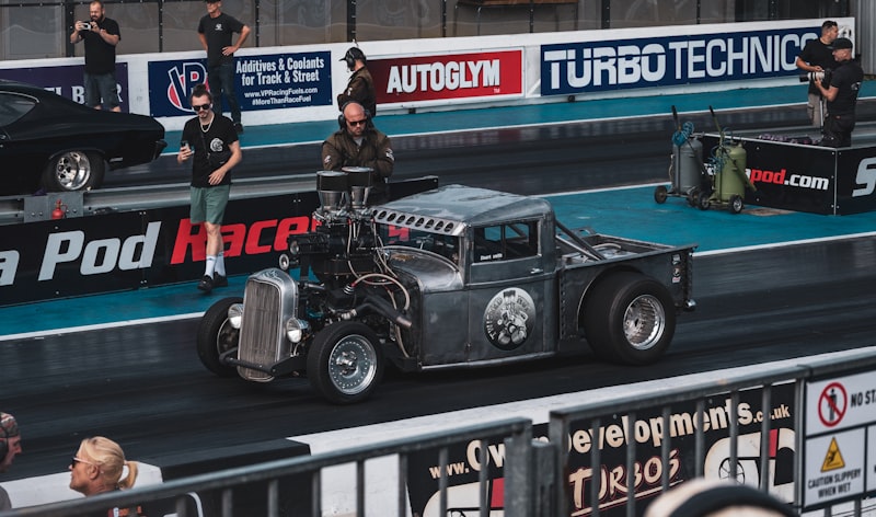 a car is driving on a track with people watching