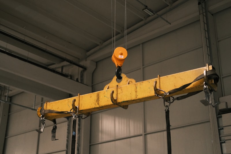 A yellow crane hanging from a ceiling in a garage
