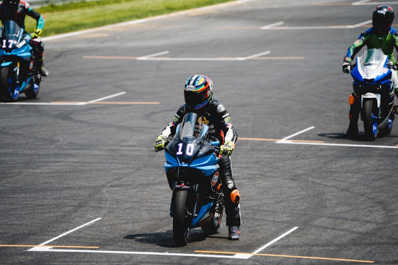 a group of people riding motorcycles on a race track