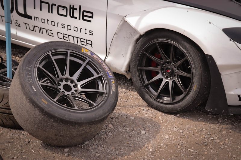 a white car parked next to a pile of tires