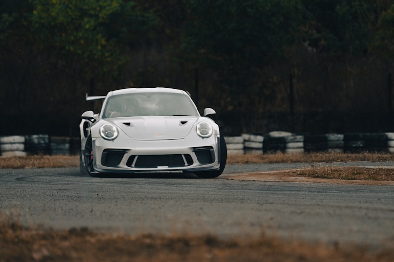 a white sports car driving down a race track