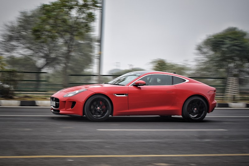 a red sports car driving down a street