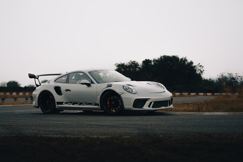 a white sports car driving down a road