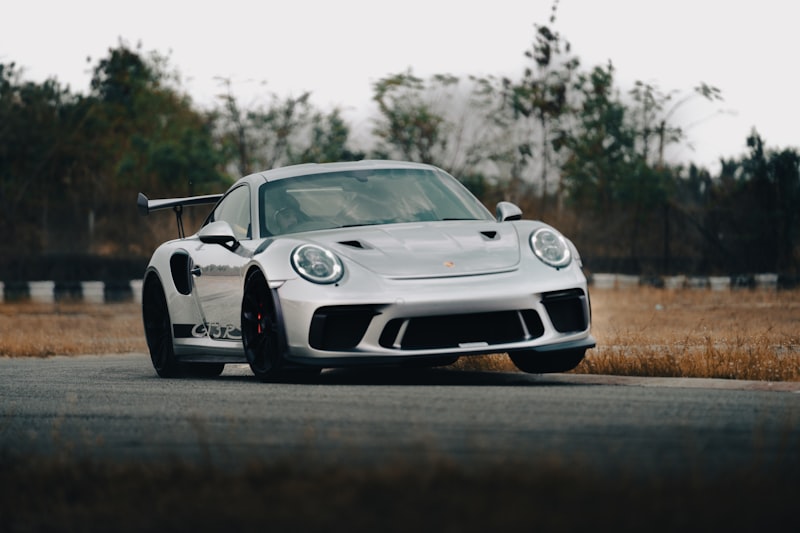 a silver sports car driving down a road