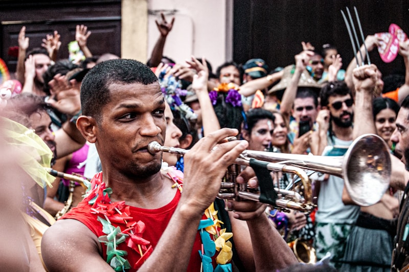 man in red tank top playing trumpet