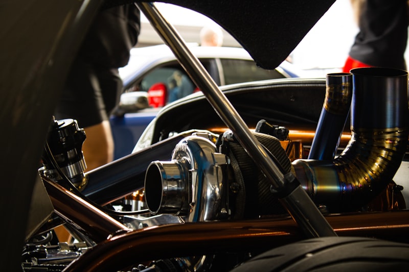 a close up of a motorcycle engine with a car in the background