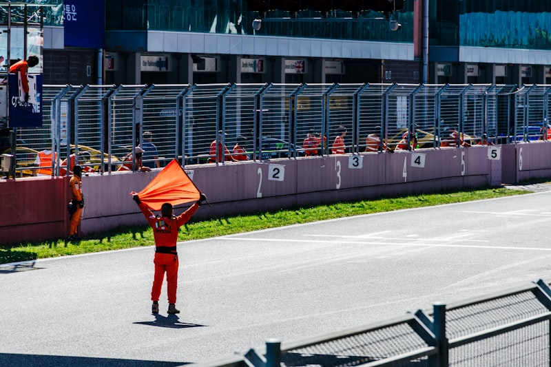 a man holding a kite on top of a race track