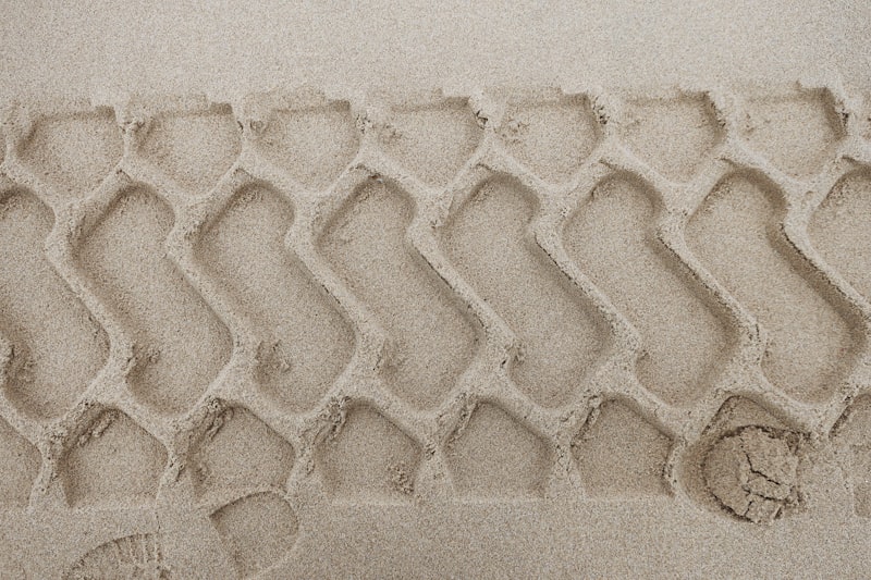 A close up of a tire tread in the sand