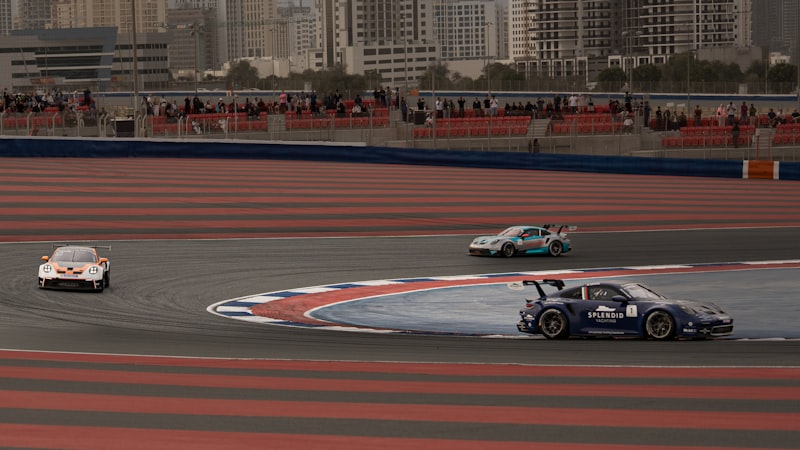 Race cars drift around a corner on a track.