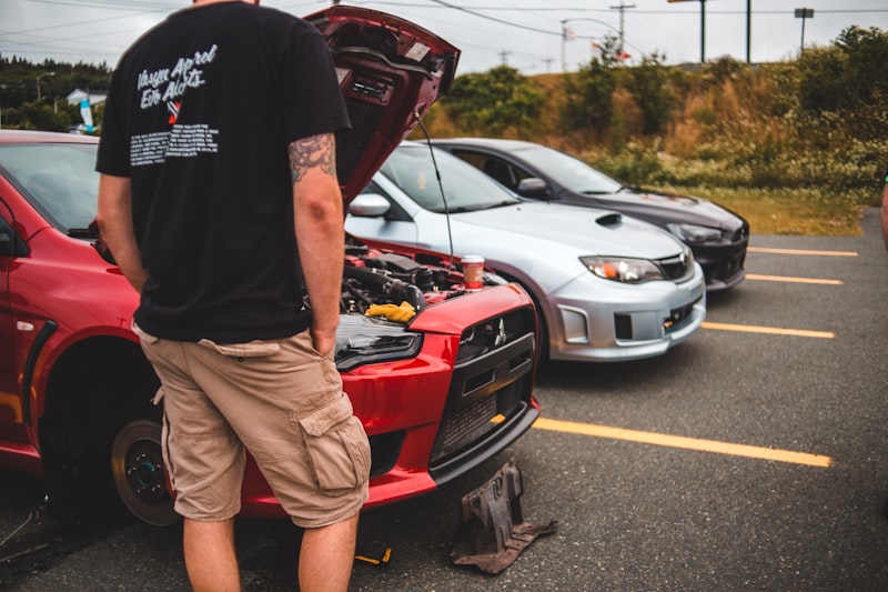 a man standing next to a car that has been involved in a accident