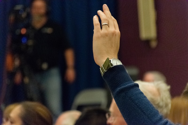 person wearing silver-colored ring rising above