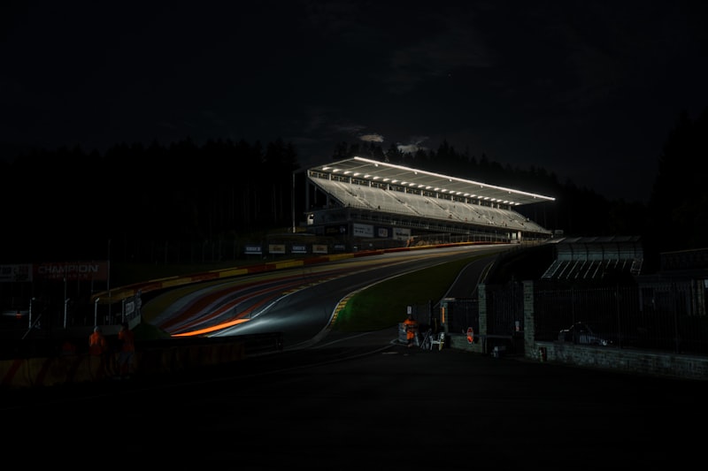 Race track grandstand illuminated at night with light trails