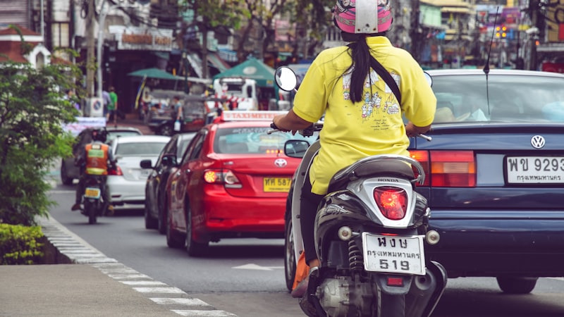 person riding black and white motor scooter