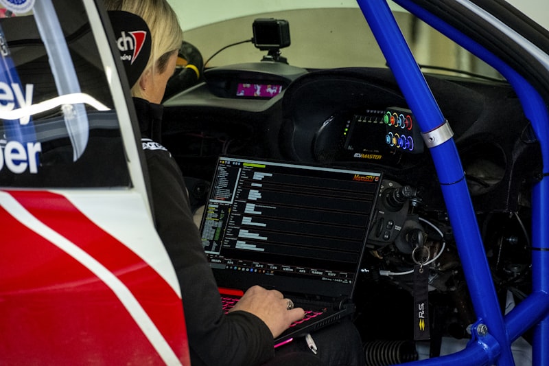 a woman sitting in a car working on a computer