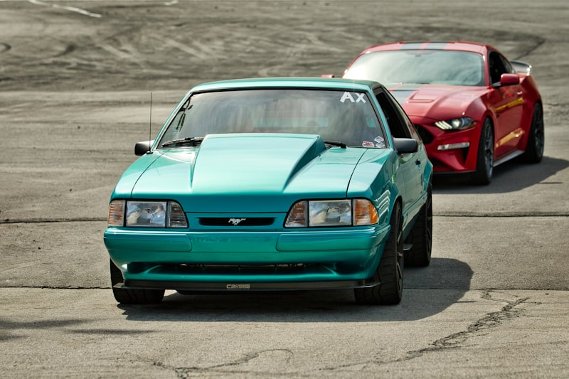 Two ford mustangs race on a track
