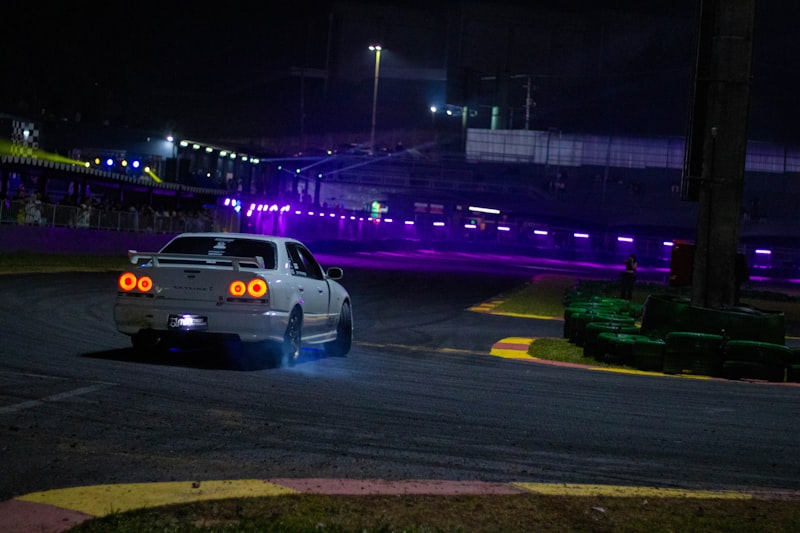 A car driving down a race track at night