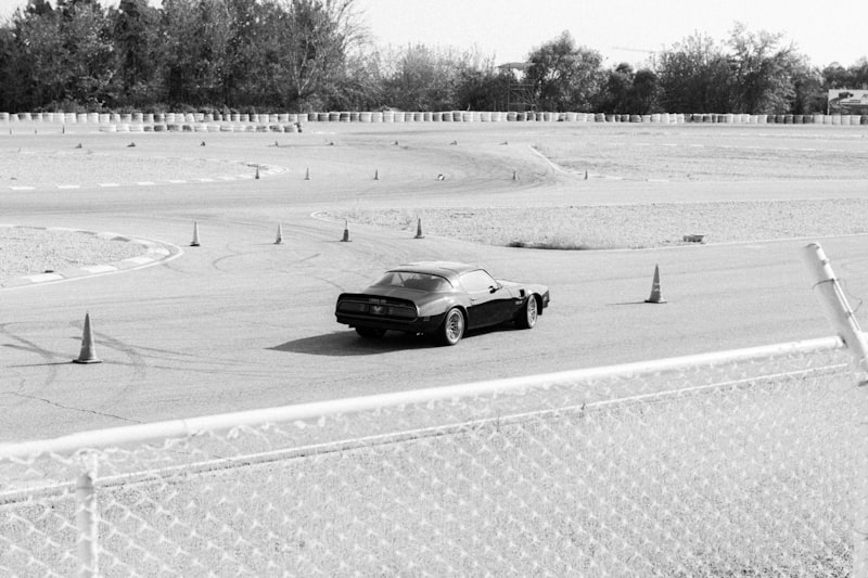 A black and white photo of a car on a race track