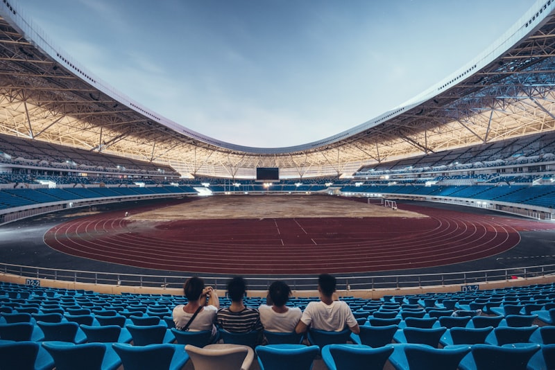four person sitting on blue chair stadium