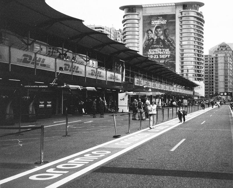 Race track pit lane with buildings and advertising banners.